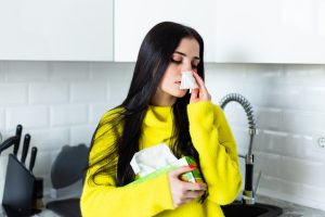 K L Contractor Plumbing Inc | Sewer Smell in House? Sewer Gas Smell Solutions – Marietta, GA – KL Plumbing Sick young woman blows her nose kitchen 231208 1089