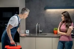 K L Contractor Plumbing Inc | What Does a General Plumber Do? – KL Plumbing Marietta, GA Woman with question gesture plumber looking broken faucet