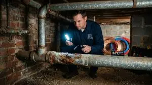 Plumber_inspecting_corroded_pipes_202605262214 Plumber,Plumber in Marietta